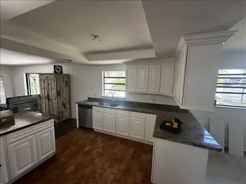 Kitchen with white raised-panel cabinets refinished with a smooth, clean finish