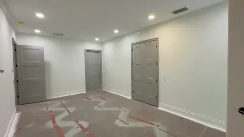 Hallway with gray painted doors and trim against smooth white walls