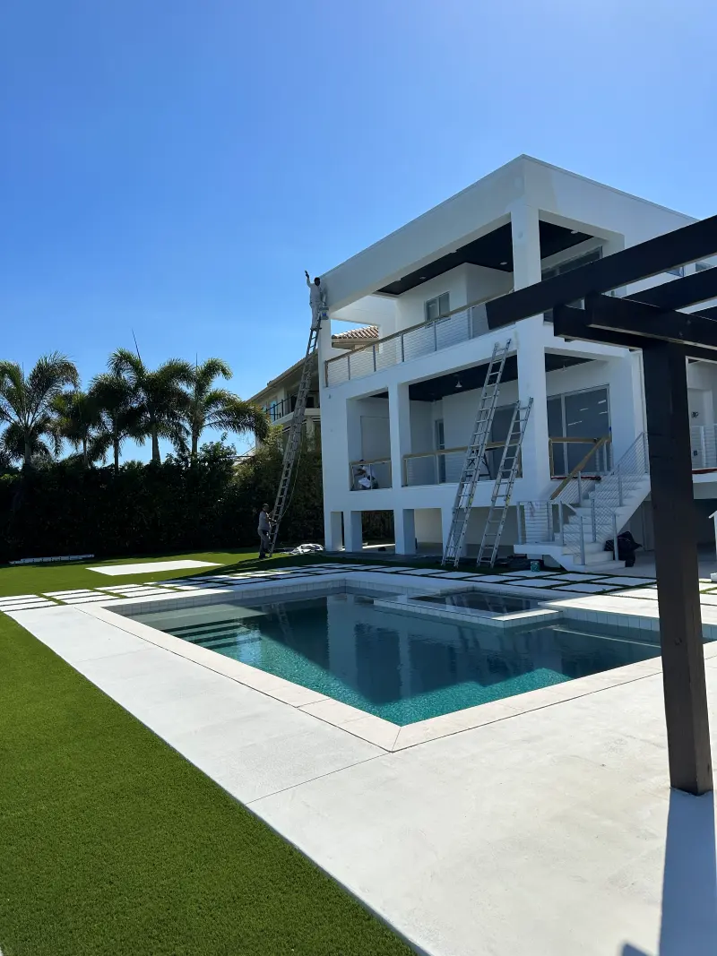 Modern white two-story home with a covered pergola beside a swimming pool