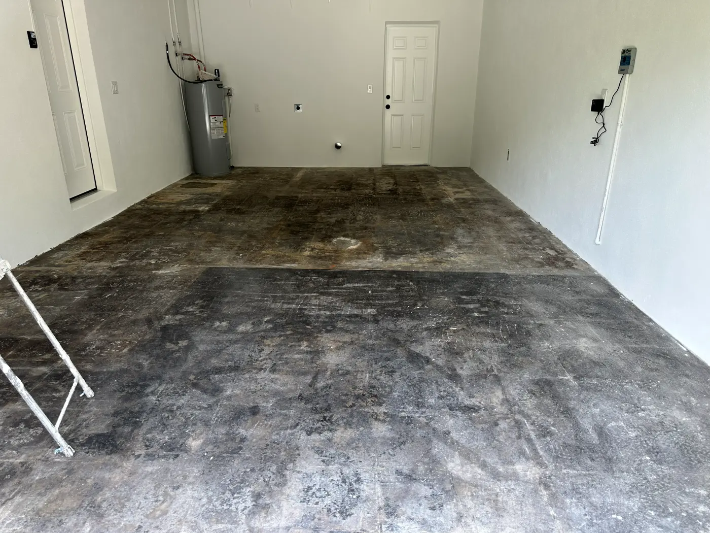 Before: garage with a bare, stained concrete floor and white walls