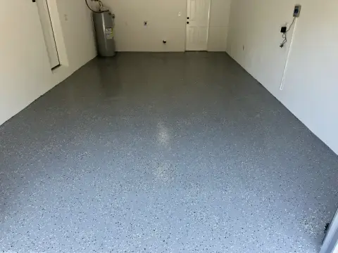 Garage with a freshly finished gray speckled floor and white painted walls