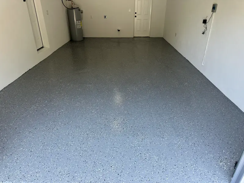 Garage with a freshly finished gray speckled floor and white painted walls