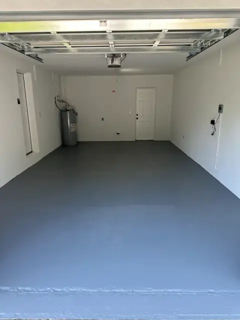 Garage floor with a smooth gray coat applied and white painted walls
