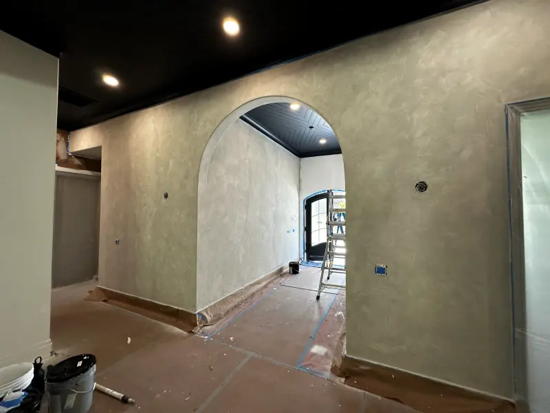 Arched hallway with soft textured limewash walls, white trim and a dark shiplap ceiling