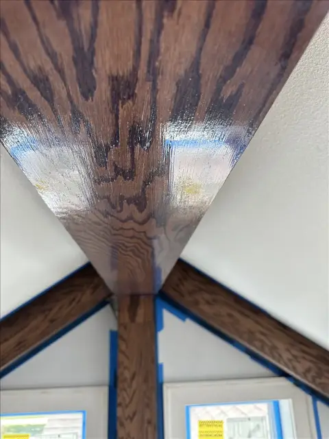 Stained wood beams meeting at a vaulted ceiling with clean edges